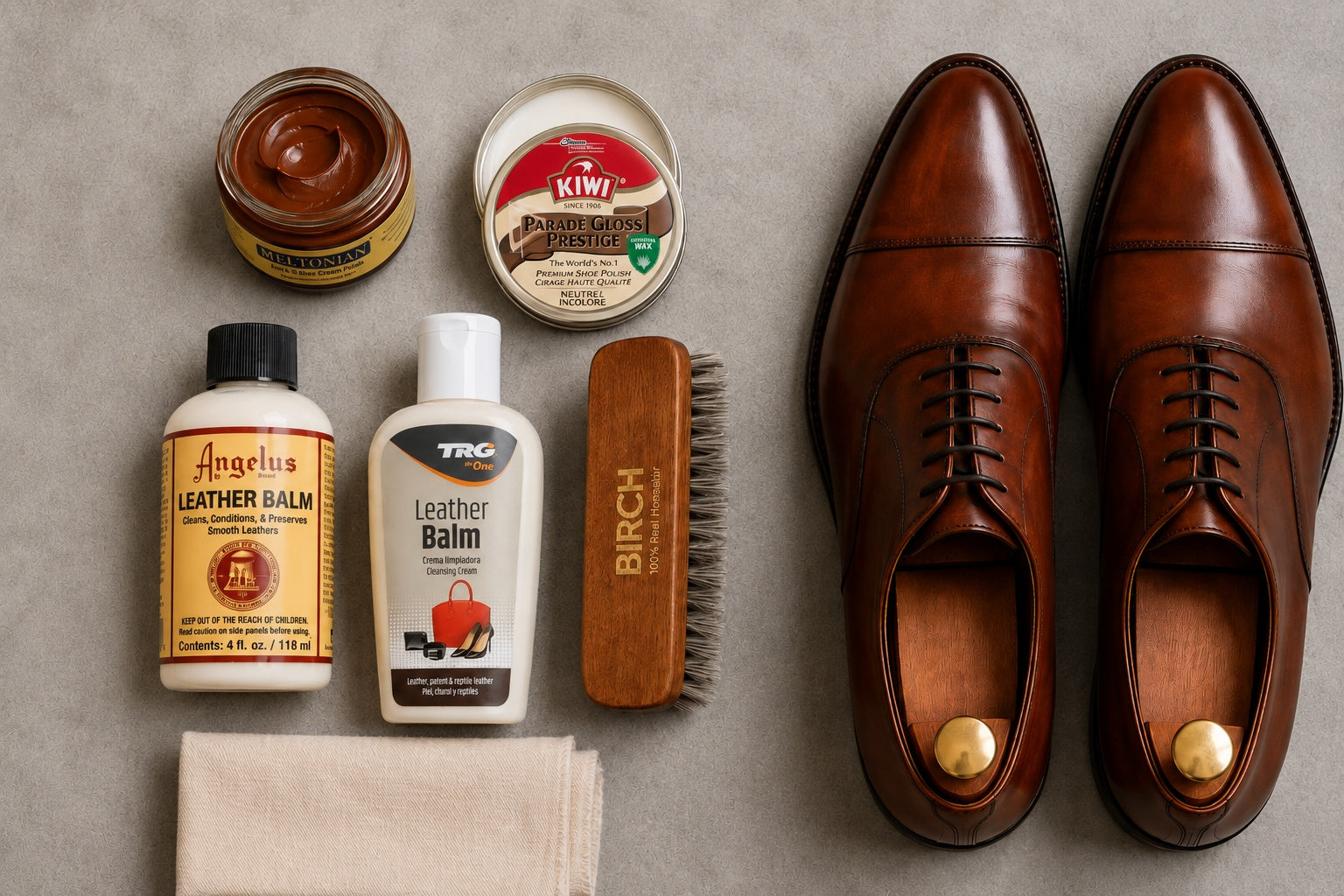 Shoe cream, wax polish and leather-care products beside polished leather shoes.