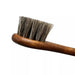 Grey horsehair dauber brush reaching intricate stitching on leather shoes